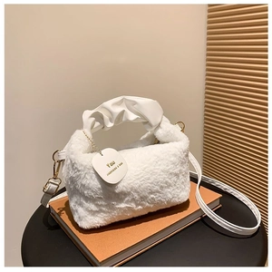 Detail of white plush handbag featuring ruched leather handle and gold metal chain strap