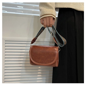 Detail of vintage brown semi-circle shoulder bag with colorful jacquard woven wide strap