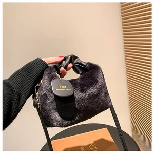 Close-up of plush faux fur cloud bag with pleated leather handle and adjustable strap