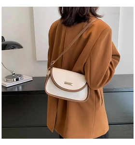 Model wearing a retro contrast shoulder bag in cream and brown with gold clasp