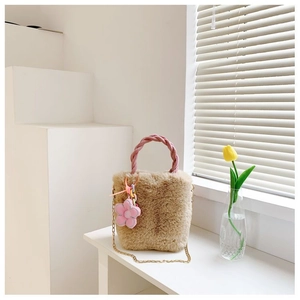 Détail macro de la fourrure synthétique brune avec anse tressée rose et bijou de sac