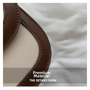 Close-up of premium brown leather texture with precise stitching on a small square bag