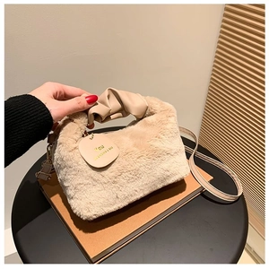 Detail of plush faux fur handbag with PU leather handle and circular VOU brand tag