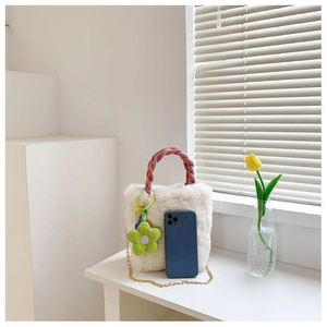 Sac seau en peluche crème avec anse rose et un smartphone pour comparer la taille