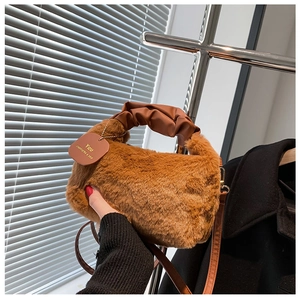 Detail of plush faux fur handbag with ruched leather handle and gold chain strap