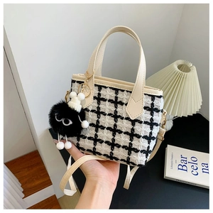 Chic black and white houndstooth wool bucket bag with plush sprite charm detail