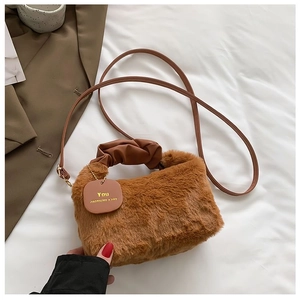 Detail of caramel plush handbag featuring soft faux fur and elegant leather handle