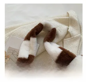 Gros plan sur la bandoulière en peluche douce à rayures marron et blanches du sac