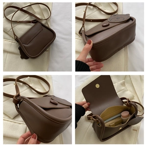 Detail of dark brown leather crossbody bag featuring a cute bear charm and interior storage