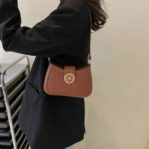 Brown quilted PU leather shoulder bag with a gold rudder buckle shown on a model