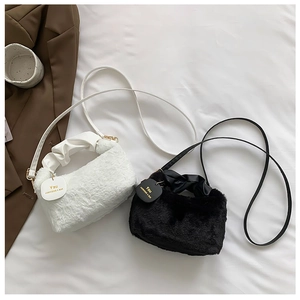 Detail of plush mini shoulder bags in black and white with ruffled leather handles and gold hardware