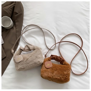 Flat lay of plush shoulder bags in beige and brown with faux leather handles