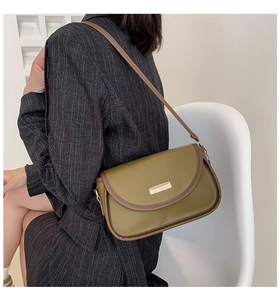 Detail of olive green vintage crossbody bag featuring gold buckle and brown piping trim