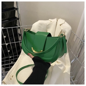 Détail du sac selle demi-lune vert émeraude avec une boucle en croissant dorée