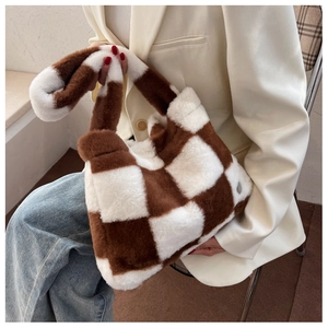 Gros plan du sac cabas damier en peluche douce marron et blanc avec texture fourrure