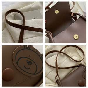 Detail view of brown leather crossbody bag with cute bear patch and magnetic closure