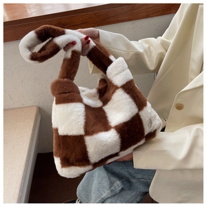 Détail du sac à main en peluche à damier marron et blanc avec texture douce en fausse fourrure