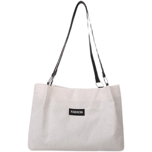 White corduroy tote bag with black leather straps and fashion label for women