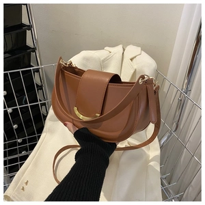 Vue détaillée du sac besace marron avec une boucle métallique dorée distinctive en demi-lune