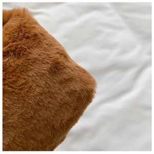 Detailed macro view of soft brown faux fur texture on a stylish plush handbag