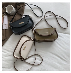 Three minimalist contrast crossbody bags in black, olive green, and off-white with gold buckles