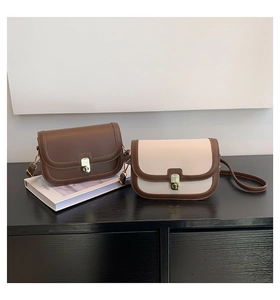 Detail view of vintage PU leather crossbody bags with golden twist lock and slim straps