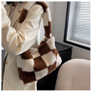 Détail du sac cabas en peluche à damier montrant sa texture en fausse fourrure marron et blanc