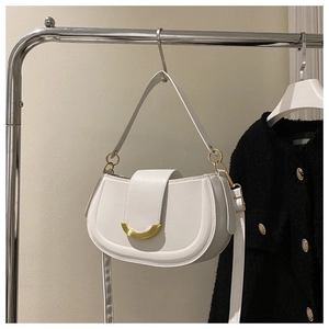 Détail du sac de selle en cuir blanc avec une boucle dorée en forme de croissant