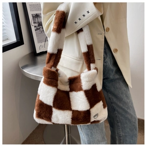 Sac fourre-tout en peluche à damier marron et blanc porté avec un blazer blanc
