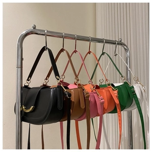 Détail de sacs selle multicolores avec boucles métalliques dorées en forme de demi-lune