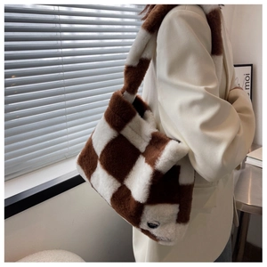 Détail du cabas en peluche à damier avec texture en fausse fourrure et bouton en métal