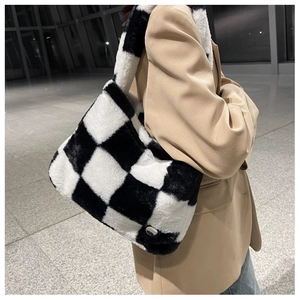 Détail du sac cabas en peluche à damier noir et blanc avec une large bandoulière