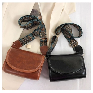 Flat lay of vintage crossbody bags with colorful ethnic style embroidered shoulder straps
