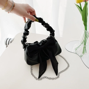 Elegant black cloud handbag with oversized bow detail and silver chain shoulder strap