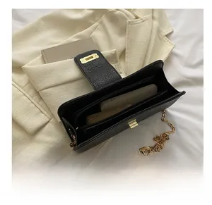 Gros plan du sac en cuir grainé montrant l'espace intérieur pour téléphone et clés