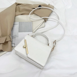 Close-up of white structured handbag featuring a vertical gold metal twist lock closure