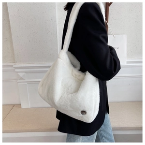 Gros plan détaillé d'un sac cabas en peluche blanche montrant la texture douce et le logo