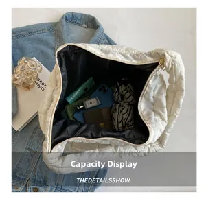 Capacity display of large white quilted tote bag showing phone wallet and umbrella inside
