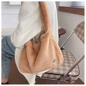 Vue détaillée du sac à main en peluche caramel avec fourrure douce et médaillon argenté