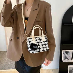 Fashionable knit houndstooth bucket bag with leather handles and monster charm