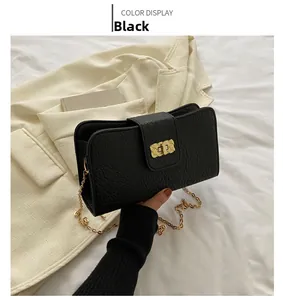 Détail du sac à bandoulière en cuir grainé noir avec chaîne dorée et fermoir métallique