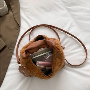 Brown faux fur plush crossbody bag with leather handles and interior storage space