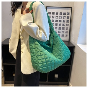 Detail of a large green quilted hobo bag with soft fabric and spacious storage design