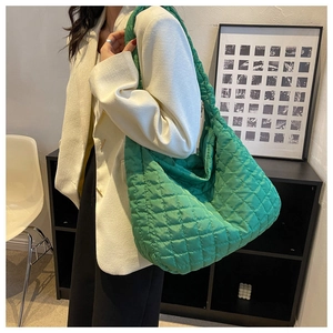 Detail of a bright green quilted puffer tote bag shown in a stylish crossbody style