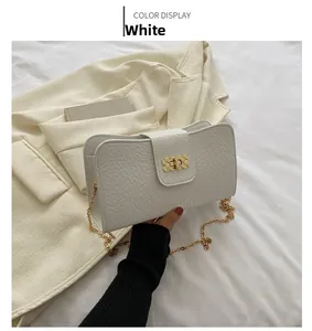 Vue détaillée du sac blanc en cuir litchi avec fermoir tournant et chaîne dorée