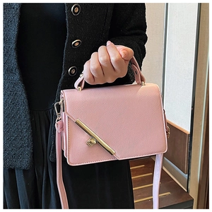 Detailed view of pink leather handbag featuring litchi texture and gold metal buckle