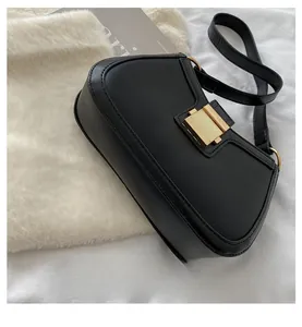 Detail view of the elegant golden square buckle and fine leather texture of the black bag