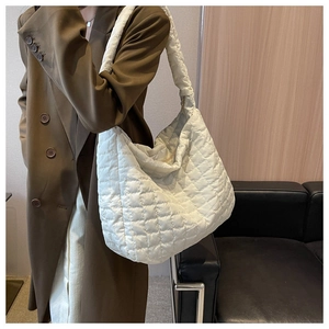 Detail of the large white quilted hobo bag with a plush texture for versatile summer wear