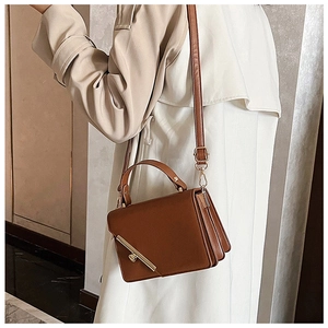 Brown leather crossbody bag featuring vintage accordion folds and golden metal clasp closure