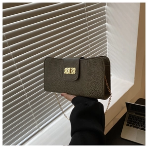Détail d'un sac bandoulière en cuir olive foncé avec texture grainée et fermoir doré